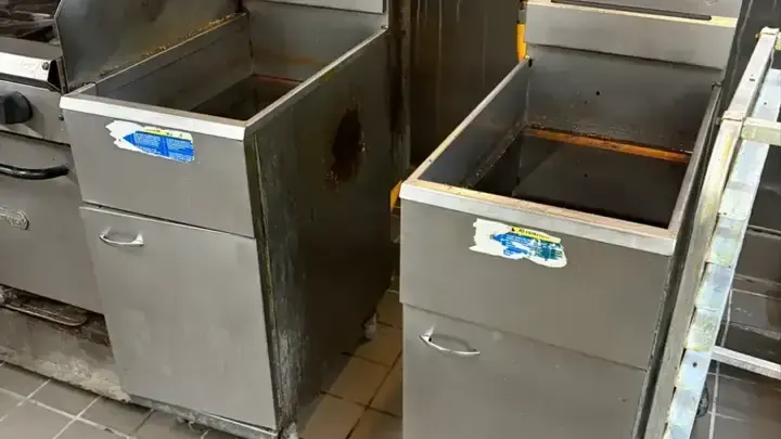Two stainless-steel fryer tanks in a restaurant cooking line.